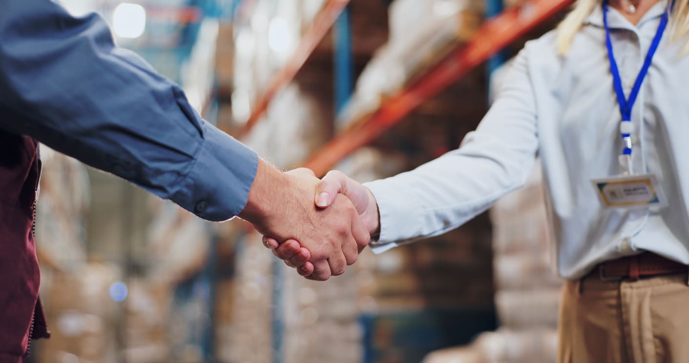 two men shaking hands in a warehouse